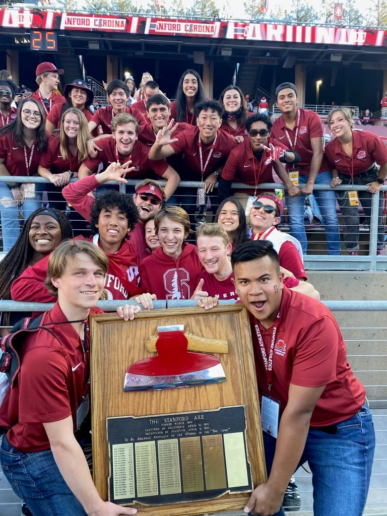 Stanford students dressed in red hold the Axe trophy.