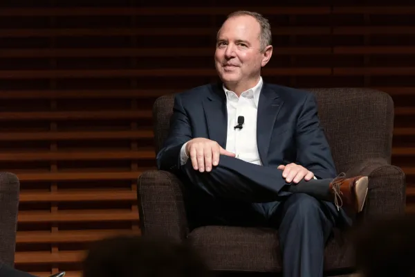 adam schiff sits in a chair on cemex auditorium's stage