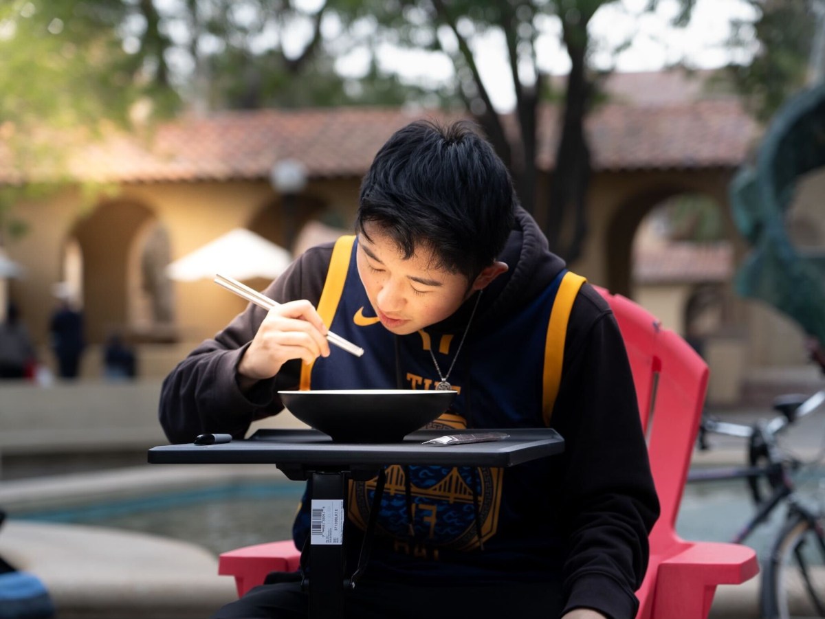 Teland La ’24 MS ’25 sitting in front of a table eating a grain of rice.