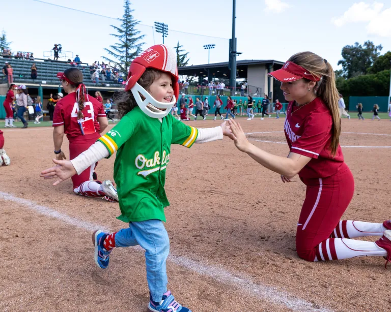 Kids run the bases before a Stanford Softball home game against Arizona State University.