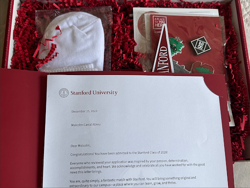 a Stanford admissions gift package, containing a letter of admission, a Class of 2028 pin, and confetti