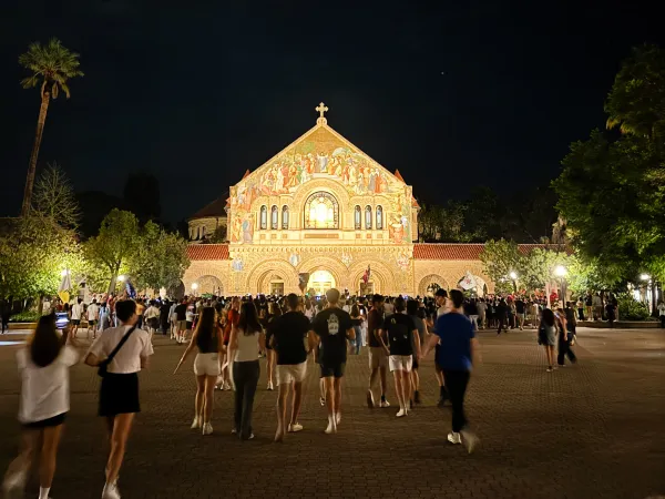 Students gather in front of Memorial Church at night. (Photo: YUSHAN YAN/The Stanford Daily)