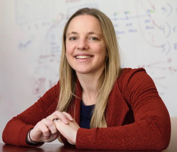 Photo of Dr. Alia Crum by a table