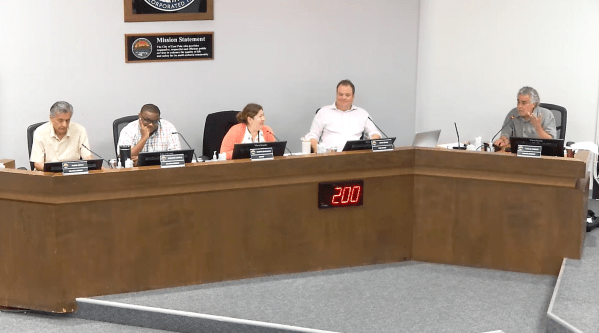 City council members sit at a conference table.