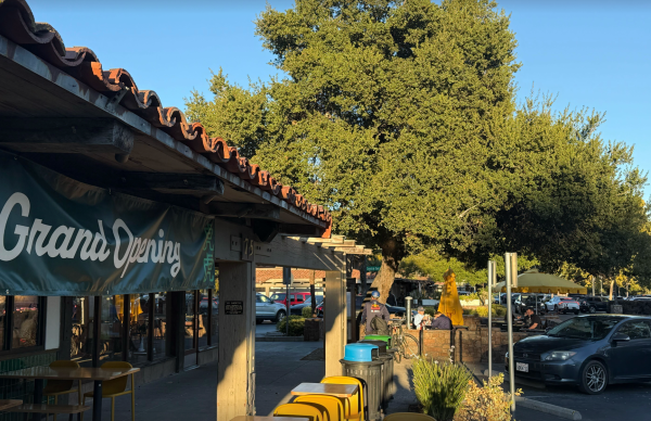 A picture of the new restaurant with a sign that reads Grand Opening
