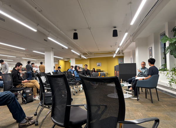 A crowd listens to Dan Wang speak in a room