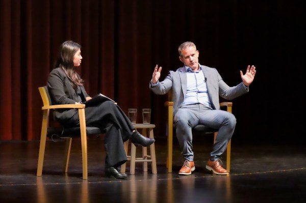 A picture of the moderator and speaker on stage