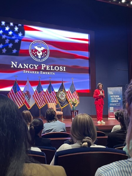 Nancy Pelosi speaks onstage in front of a crowd.