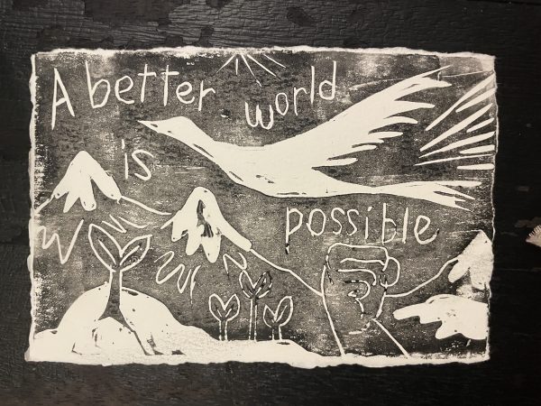 A black-and-white drawing that reads "A better world is possible." The text is surrounded by birds and flowers.