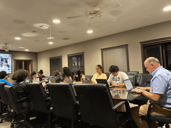 The UGS seated around a table for its weekly meeting