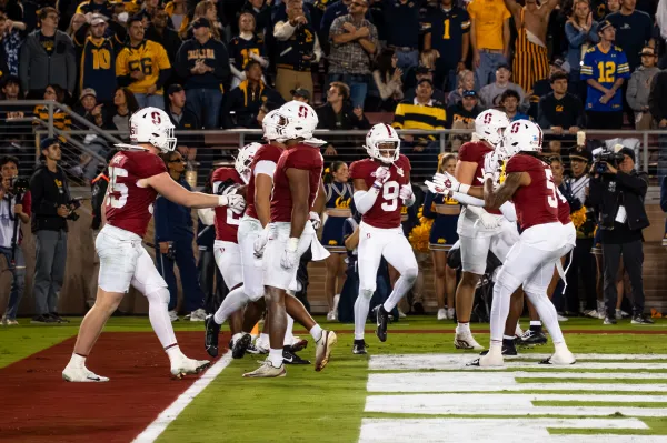 The Stanford defense celebrates in the end zone during the 128th Big Game at Stanford Stadium on Saturday night. The Cardinal defense returned two Cal fumbles for touchdowns in the 31-10 win. (Photo: MICHAEL YU/The Stanford Daily)