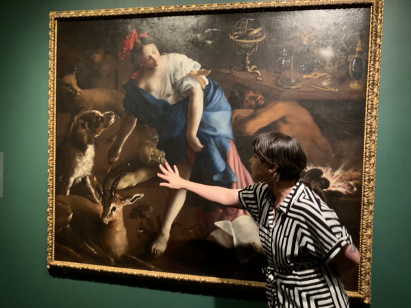 A Cantor employee showcases a painting of a sorceress by Bartolomeo Guidobono at the "Cunning Folk" exhibition.