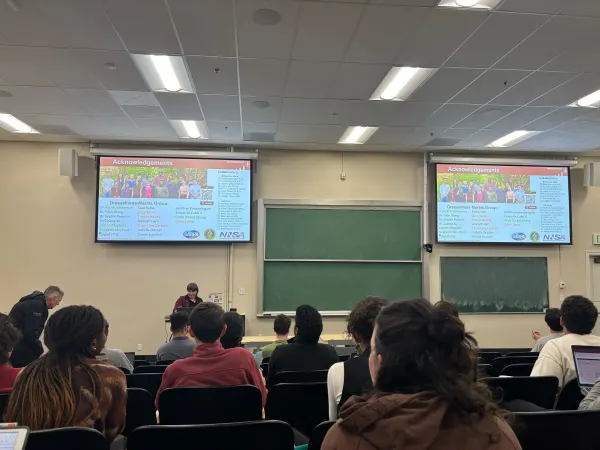 People watch the Stanford Energy Seminar in a classroom-style room.