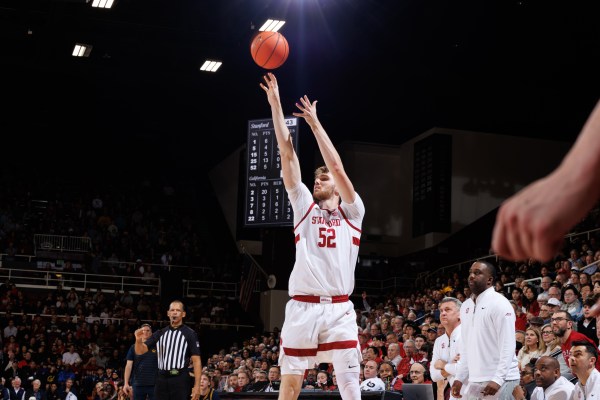 Basketball player shoots ball during game.