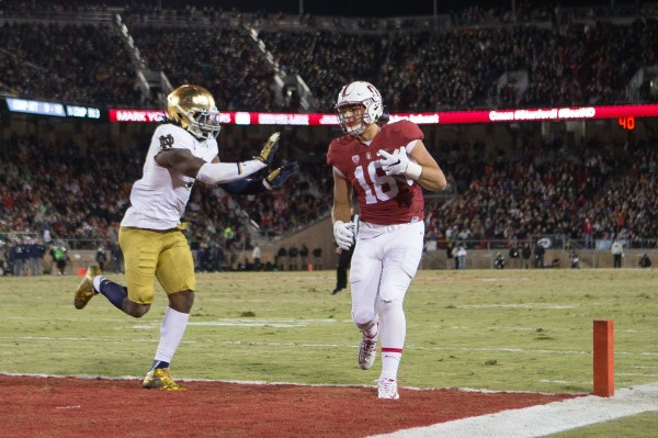 Football player holds ball in endzone.