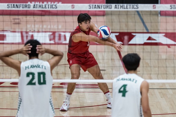 Men's volleyball player hits a dig on the court.