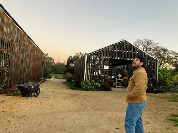 Sergio Sanchez stands in front of the stanford farm structure