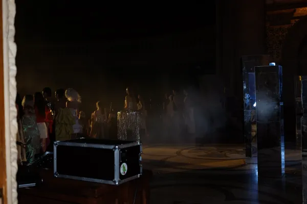 Backstage with models in distance.