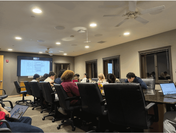 UGS members gather around table to give presentation