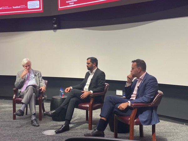 The two panelists and a moderator sit in a lecture hall.
