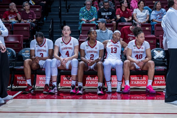 Stanford women's basketball players sit on the bench during a game.
