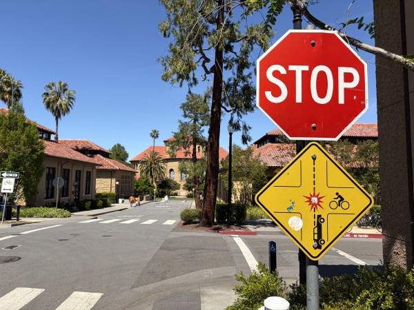 A stop sign at an intersection with a yellow sign warning against a collision.