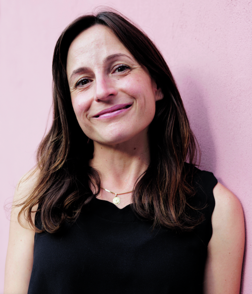 Headshot of Professor Karen Russell in a black tank top, standing before a pink backdrop.
