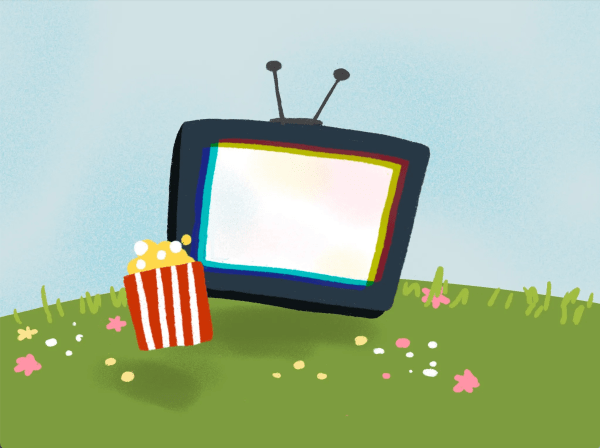 A TV screen with popcorn in front of it on a blooming grass field.
