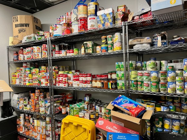 A shelf of canned and dry food for the homeless.