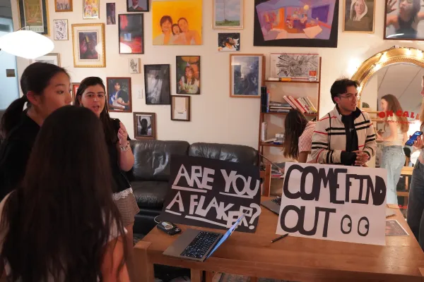 Students gather around a table with signs that say "Are you a flaker? Come find out"