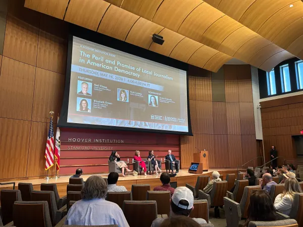 Panel discussion at Hoover Institution on local journalism's role in democracy. Moderators and speakers on stage with audience seated.