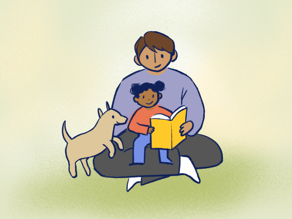 A child sits in their parent's lap while reading a book. their pet dog hops up to listen in.