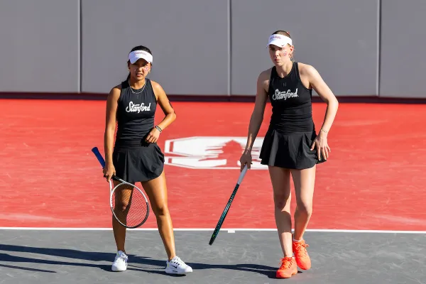 Two Stanford women's tennis players posing with their rackets for an outdoor photo
