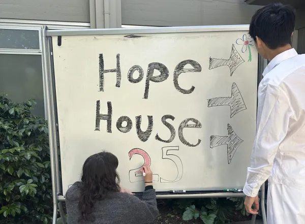 Members of the Hope House Scholars program write out sign that read Hope House 25.