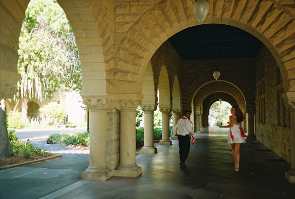 Two seniors running down the arcades