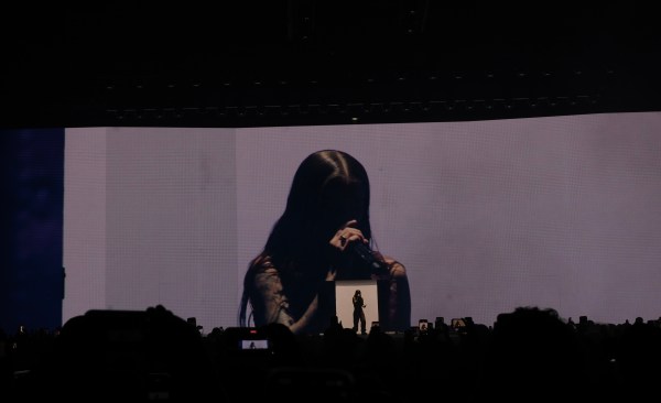 Screen shows Young Miko holding a mic as she stands in the foreground.