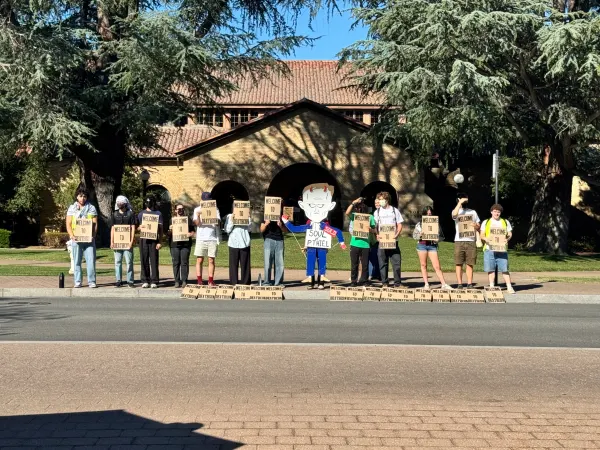 A group of students organized to contest the presence of defense contracting companies at Encina Hall. (KALEB GJESTSON / The Stanford Daily)