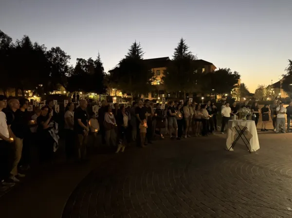 Attendees set candles in the center of Meyer Green. (Photo: NICHOLAS MILLER/The Stanford Daily)