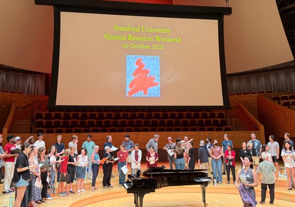 Singers stand on stage in a half circle.