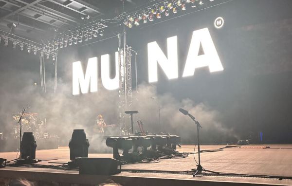The stage at Frost Amphitheater ahead of MUNA’s two-hour set, showing a sign reading "MUNA" in bright, glowing lights.