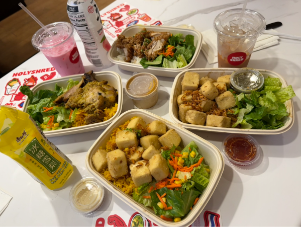 Writer's HolyShred order, featuring from top: larb chicken bowl, thai tea, herb-infused noodles, tofu garlic rice, pear juice, chicken satay, pink drink, sparkling peach juice.
